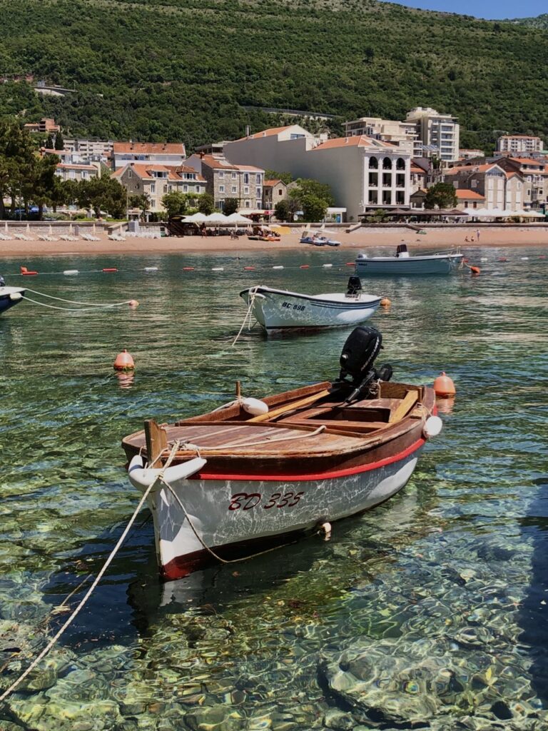 10 Most Beautiful Places in Montenegro - crystal clear water with vintage fishing boat