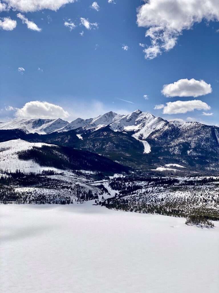 frozen and snow covered Dillon Reservoir with snow capped mountain backdrop 