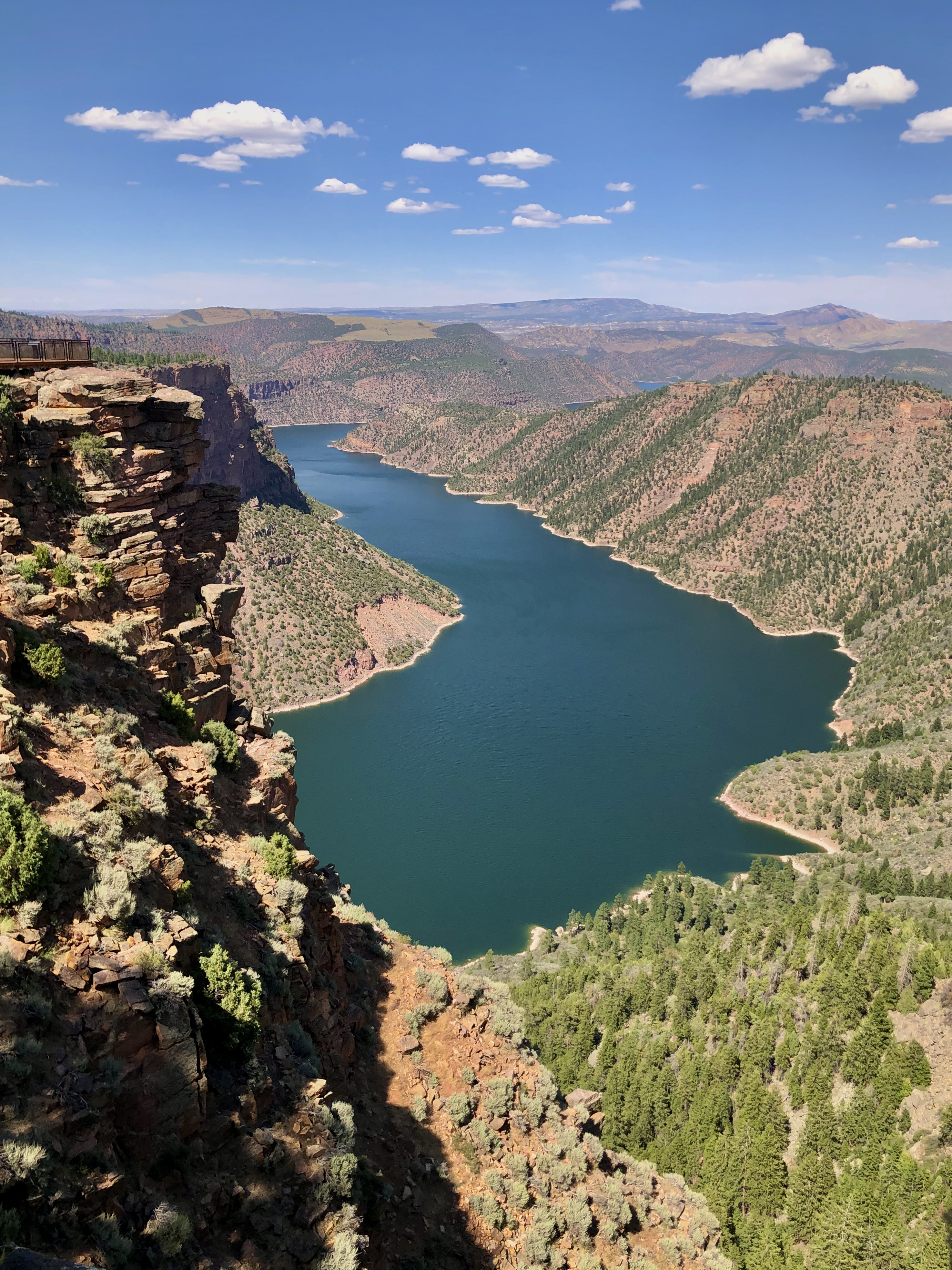 Blueish-green tinted waters deep set in a gorge with red canyon walls surrounding the waters.  8 amazing places to visit on a utah road trip. 