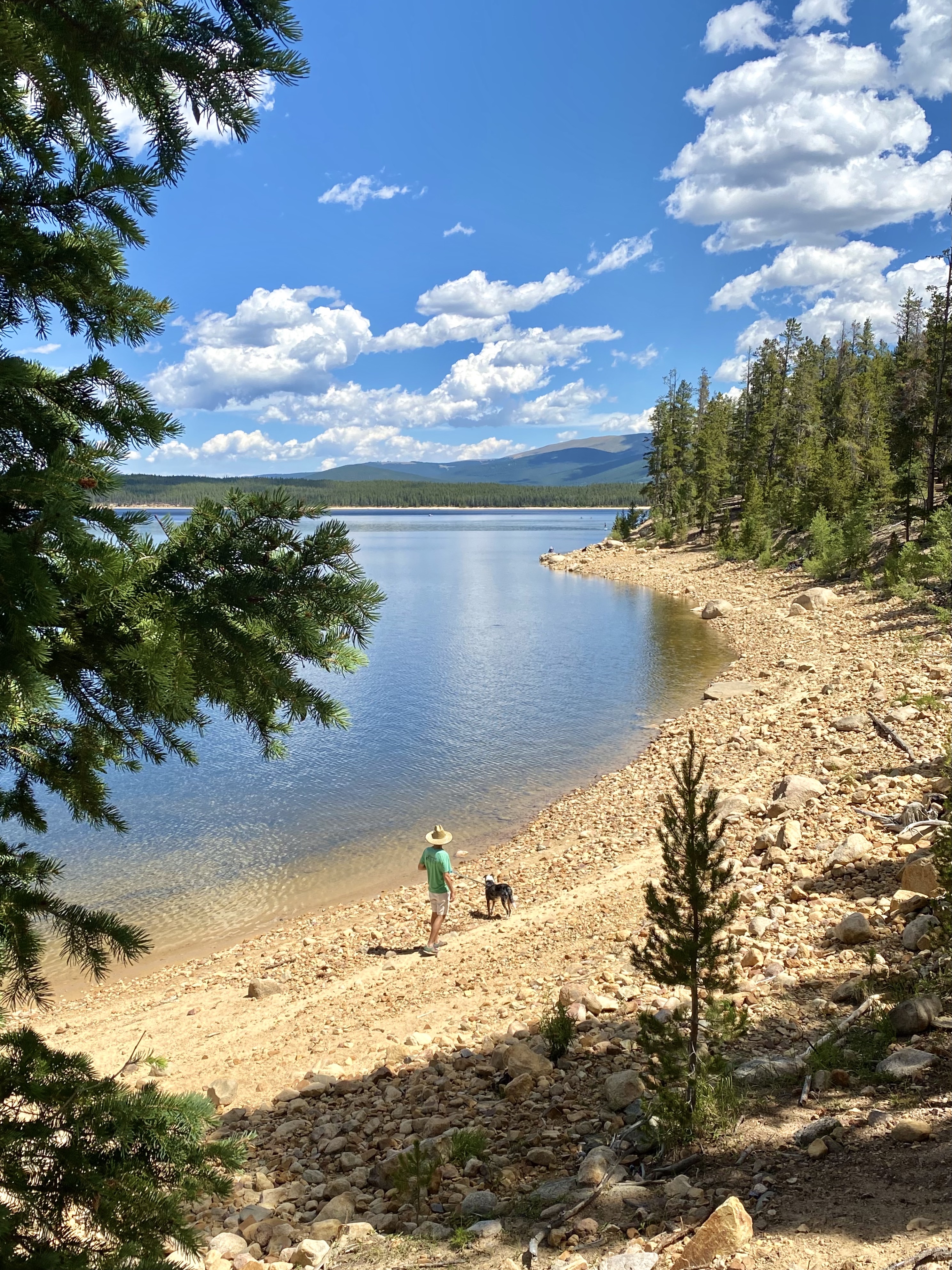 7 stunning lakes to visit in colorful colorado - jonathan and queso standing at the edge of a turquoise lake. 