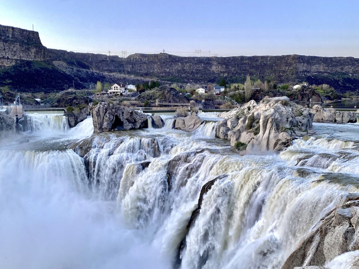 large waterfall flowering over gray rocks.